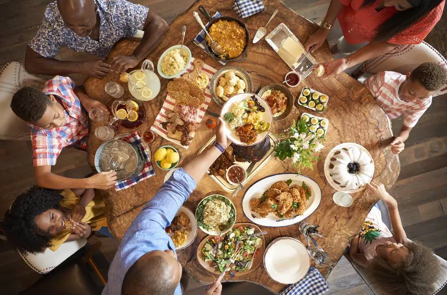 A group of people sitting around a table with food.